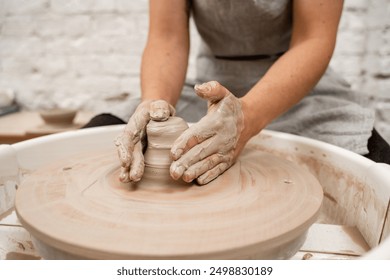 Forming the proper size and shape of pottery with increasing speed of a pottery wheel. Making a bowl on a pottery wheel with your own hands - Powered by Shutterstock