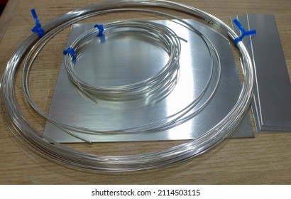 Forms of Sterling Silver Raw Materials Including Wire, Sheet And Strips Laying on Wooden Work Surface