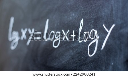 Formula with logarithms written on a blackboard with chalk