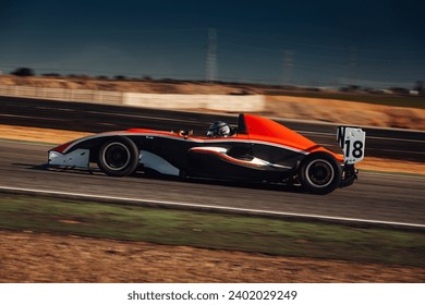 Formula one car go fast at the raceway during sunset - Powered by Shutterstock