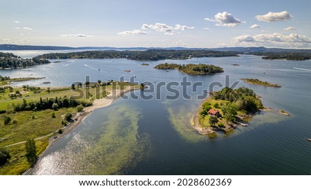 Fornebu beach in Oslo, Norway with fjords in the background and boats on the sea
