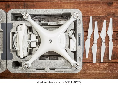 FORT COLLINS, CO, USA - DECEMBER 11, 2016:  DJI Phantom 4 pro quadcopter drone in a custom case on a rustic wooden  table with a set of propelelrs.