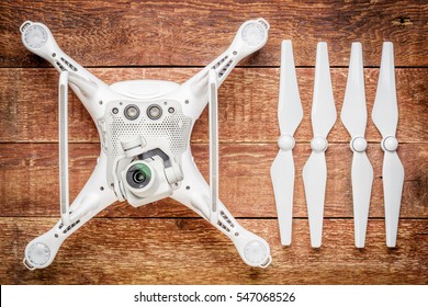 FORT COLLINS, CO, USA - JANUARY1, 2017:  DJI Phantom 4 pro quadcopter drone with propellers on a rustic wooden table, bottom view showing a camera and sensors.