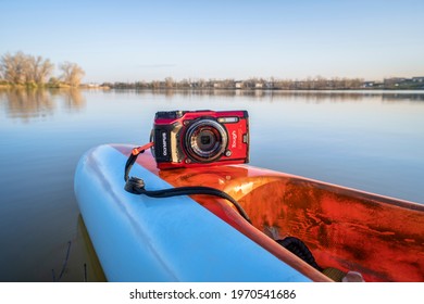 Fort Collins, CO, USA - May 6, 2021: Compact, waterproof Olympus Stylus Tough TG-5 camera on a rear deck of a stand up paddleboard by Mistral, early spring lake scenery in Colorado.