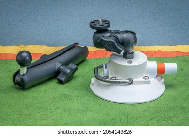 Fort Collins, CO, USA - October 6, 2021: RAM Camera Mount With Extension And Suction Cup By SeaSucker Against Abstract Paper Landscape, Accessories For Sport And Adventure Photography.