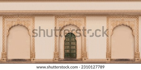 Fort, Colored Indian door with green wood and white stone, Wooden green door entrance in Mehrangarh (Meherangarh) Fort, Jodhpur, Rajasthan, India. Ornate brass door set in white marble frame,vintage.
