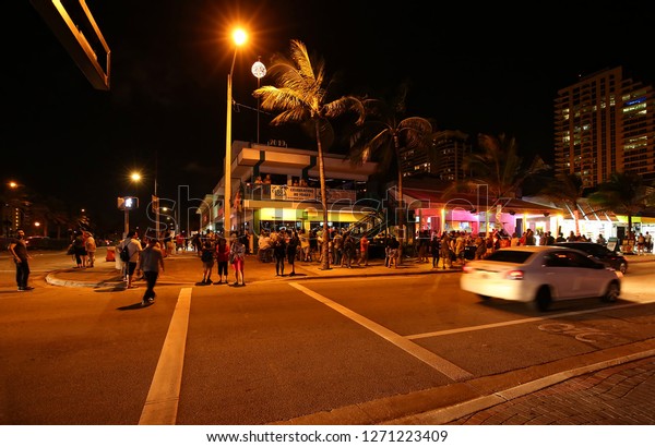 FORT LAUDERDALE, FLORIDA - DECEMBER:  In the\
evening tourist gather to celebrate New Years on Fort Lauderdale\
Beach at the corner of Las Olas Boulevard and State Road A1A as\
seen on December 30, 2018.
