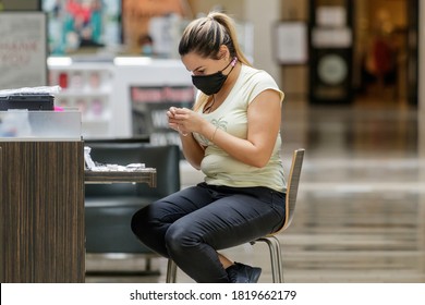 Fort Lauderdale, Florida / USA - 9/10/2020: Young Female Woman Employee Working On A Small Costume Jewelry At A Plantation Shopping Mall Kiosk Aka RMU (Retail Merchandising Unit) With Covid Face Mask