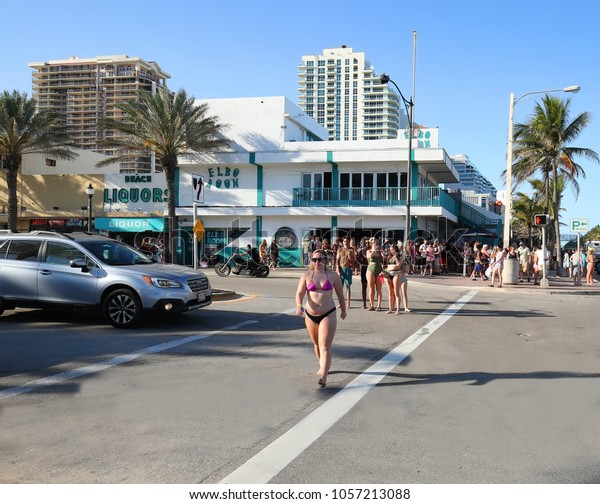 FORT LAUDERDALE,
FLORIDA, USA:  College students on Spring Break having fun on a
dare crosses the street in front of the iconic Elbow Room Dive Bar
as seen on March 5, 2018. 