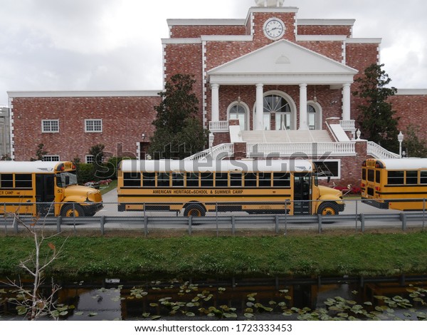 Fort\
Lauderdale, Miami- December 2018: Side view of yellow school buses\
for American Heritage School & Summer Camp.\
