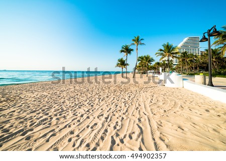 Fort Lauderdale  South Florida beach with no one on it on beautiful blue sky morning with hotels in background