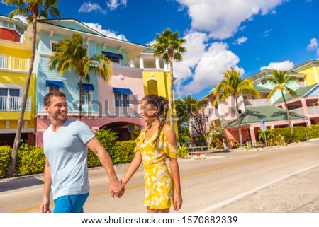 Fort Myers Beach traditional colorful cottages houses - Couple on winter vacation in sun walking holding hands near Fort Myers Beach.