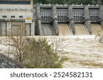 Fort Patrick Henry Dam, spilling, muddy flood waters from four spillways. Located in Sullivan County in Kingsport, Tennessee on the South Fork Holston River.