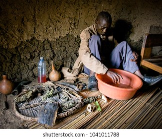 FORT PORTAL, UGANDA - Dec 2009: A Ugandan Witch Doctor Sits Among Ritual Paraphernalia In A Small Village Near Fort Portal In Uganda, East Africa