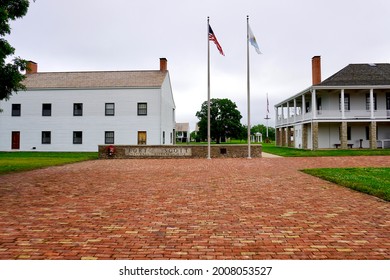 Fort Scott, Kansas -2021: Fort Scott National Historic Site. Entrance to frontier outpost. Sign with American and Kanas flags, infantry barracks and visitor center in the old hospital. Brick walkway. 