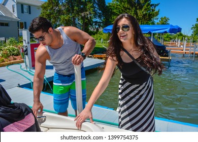 Fort Wayne, Indiana/USA- July 2014:  Beautiful Young Couple In Sunglasses Standing Next To Speed Boat, Getting Ready To Come Aboard.  