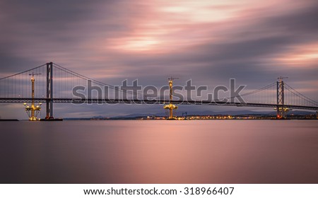 Forth Road Bridge and the Queensferry Crossing under construction in Edinburgh, Scotland, United Kingdom. Long exposure.