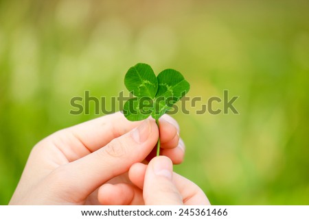 Similar – young hand in turquoise jacket holds four-leaf green clover