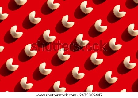 Fortune cookies in a consistent pattern on a bright red backdrop, offering a strong visual contrast. Suitable for designs emphasizing luck, fortune, simplicity, and Asian cultural elements.