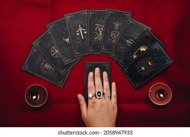 Fortune teller female hands and tarot cards on a red table. Divination concept.  - Shutterstock ID 2058947933