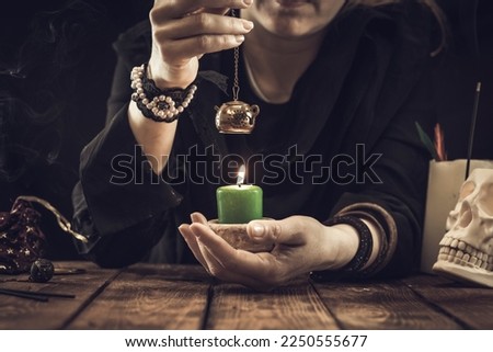 Fortune teller or oracle with items and a lit candle. Psychic readings and clairvoyance concept.