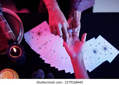 Fortune teller pointing at love line on palm of female client - Shutterstock ID 2179168445