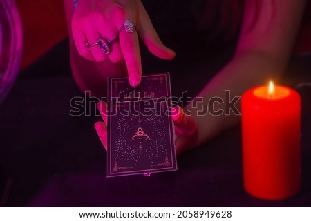 Fortune teller reading a future by tarot cards in the light of candle concept. Fortuneteller mixing cards.