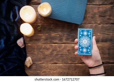 Fortune Teller With Tarot Cards In The Hand On Brown Table Background.