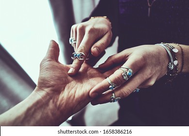 Fortune teller woman wearing silver rings with turquoise stone and bracelets reads palm lines during fortune telling and prediction the future. Palmistry and occult divination      