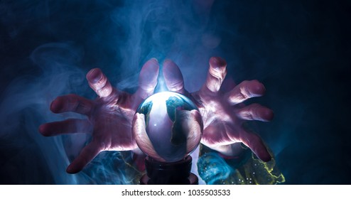 A fortune teller works in a dark room with a crystal ball