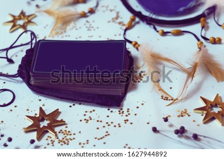 Fortune telling a deck of tarot cards with other fortune telling items blue pastel background