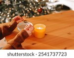 Fortune telling with melting tin.woman examines a piece of molten tin in her hands.lead pouring set for Christmas fortune telling.Mysterious and mystical atmosphere of the task.