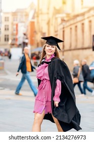 Forty - Year - Old Happy Woman In Graduation Gown Walking Around City Center.  Study At Any Age