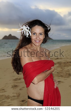 forty year old woman in red chiffon on the beach in hawaii