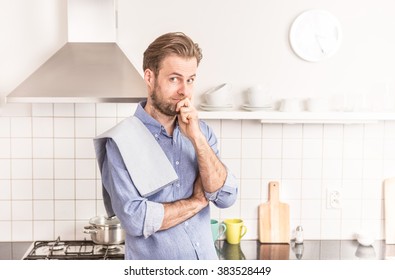 Forty years old caucasian man or chef  standing in the bright kitchen. 