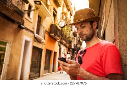 Forty Years Old Caucasian Tourist Man Looking At Mobile Phone Outdoor Near Old City Buildings - Summer Holiday