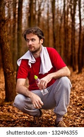 Forty Years Old Runner Man Drinking Water And Having A Rest After Jogging Workout In Autumn Forest