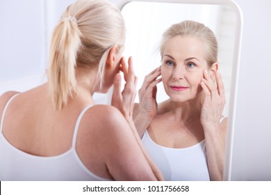 Forty Years Old Woman Looking At Wrinkles In Mirror. Plastic Surgery And Collagen Injections. Makeup. Macro Face. Selective Face