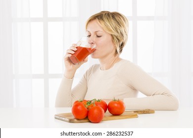 Forty years woman drinking tomato juice