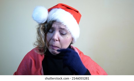 A Forty-year-old Blonde Woman In A New Year's Red Cap Is Crying. Sad Christmas. New Year