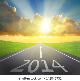 Forward to 2014 new year concept , asphalt road with arrow , date and beautiful sunset and sunshine