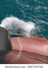 
Forward draft mark on bow of cargo ship with ocean wave and spray, ship hull Plimsoll mark, maritime navigation, vessel displacement measurement, nautical scale on red ship hull
