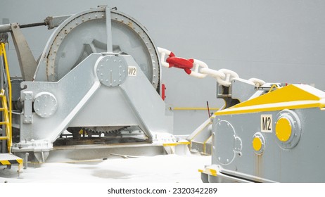Forward part, windlass and anchor chains of ultra large container ship and stored cargo containers and pacific ocean water  view during bad snowy weather.