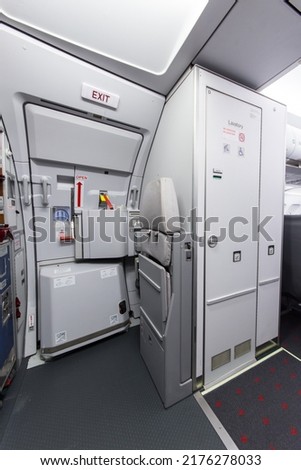 Forward section of an Airbus A320 cabin with exit door and a toilette compartment
