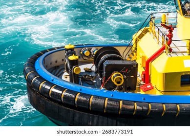 Forward section of a large tugboat with a robust rubber fender surrounding the bow. 