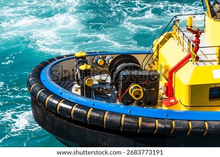 Forward section of a large tugboat with a robust rubber fender surrounding the bow. 