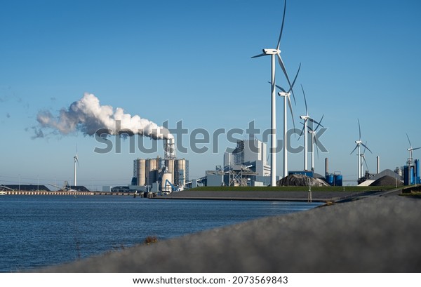 Fossil fuel\
(coal) power station and wind turbines in the Eemshaven generating\
power. Energy transition\
concept.