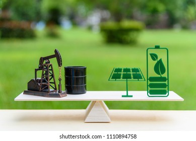 Fossil Fuel Vs Renewable / Future Clean Alternative Energy Concept : Petroleum Pumpjack, Crude Oil Drum Barrel And Solar Panel, Green Battery With Leaf On A Simple Wood Balance Scale In Equal Position