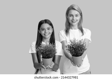 Foster to adopt. Foster family. Adopted daughter and mother hold houseplants. Child adoption