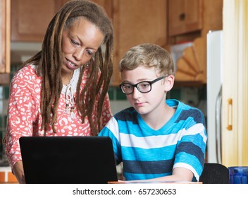 Foster Parent Helping Child In Eyeglasses Working On Laptop